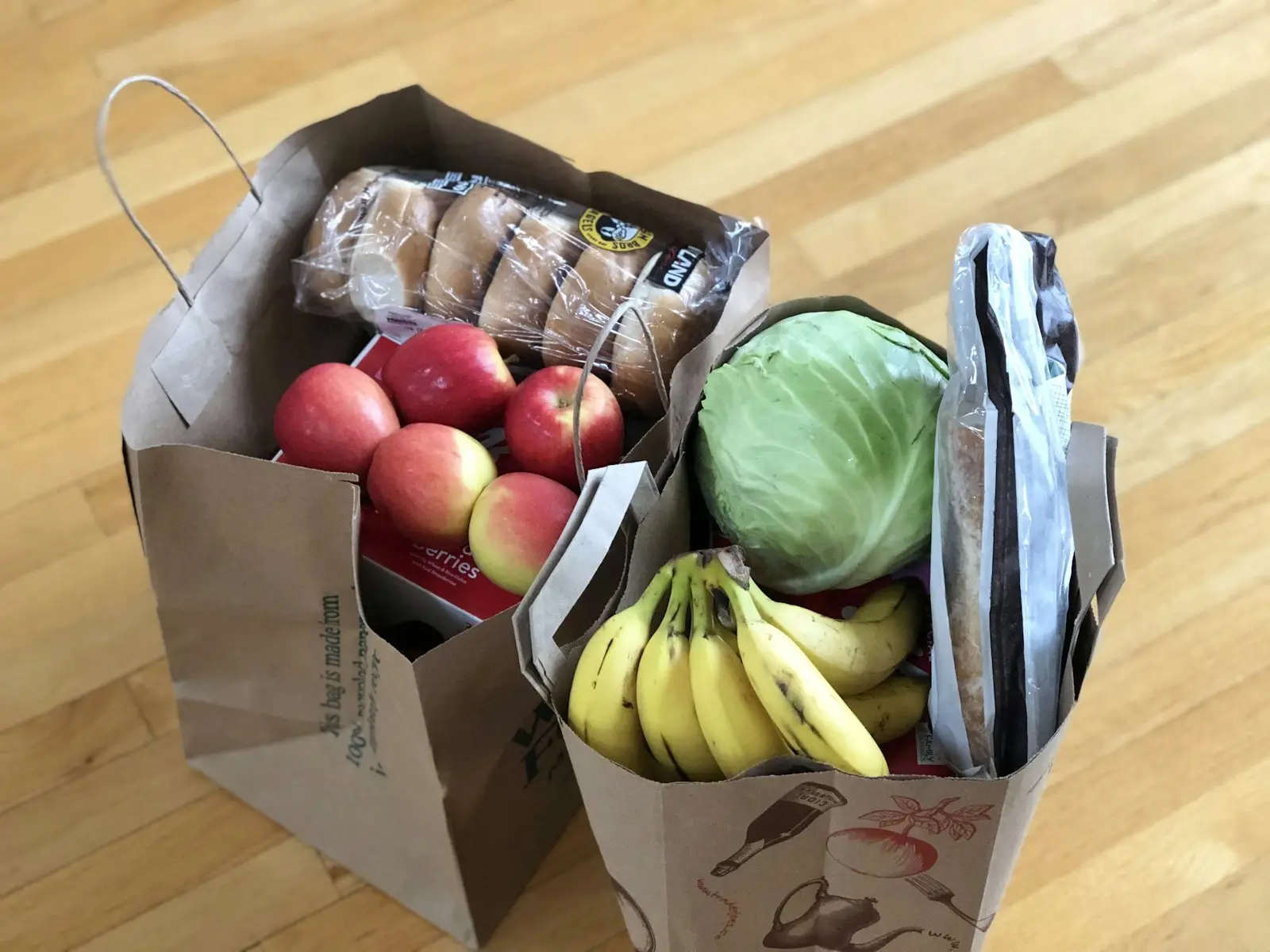 Бумажные пакеты с продуктами: яблоки, бананы, капуста, хлеб