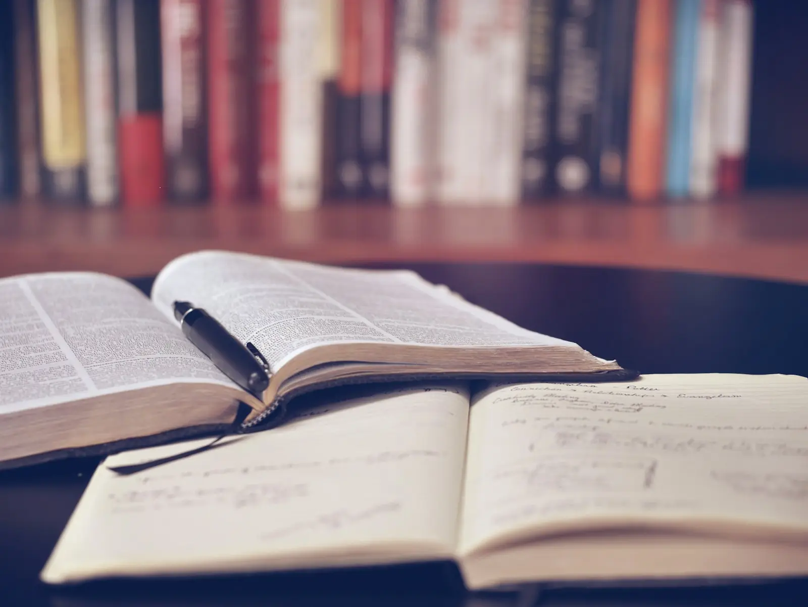 Открытая тетрадь с записями и книги